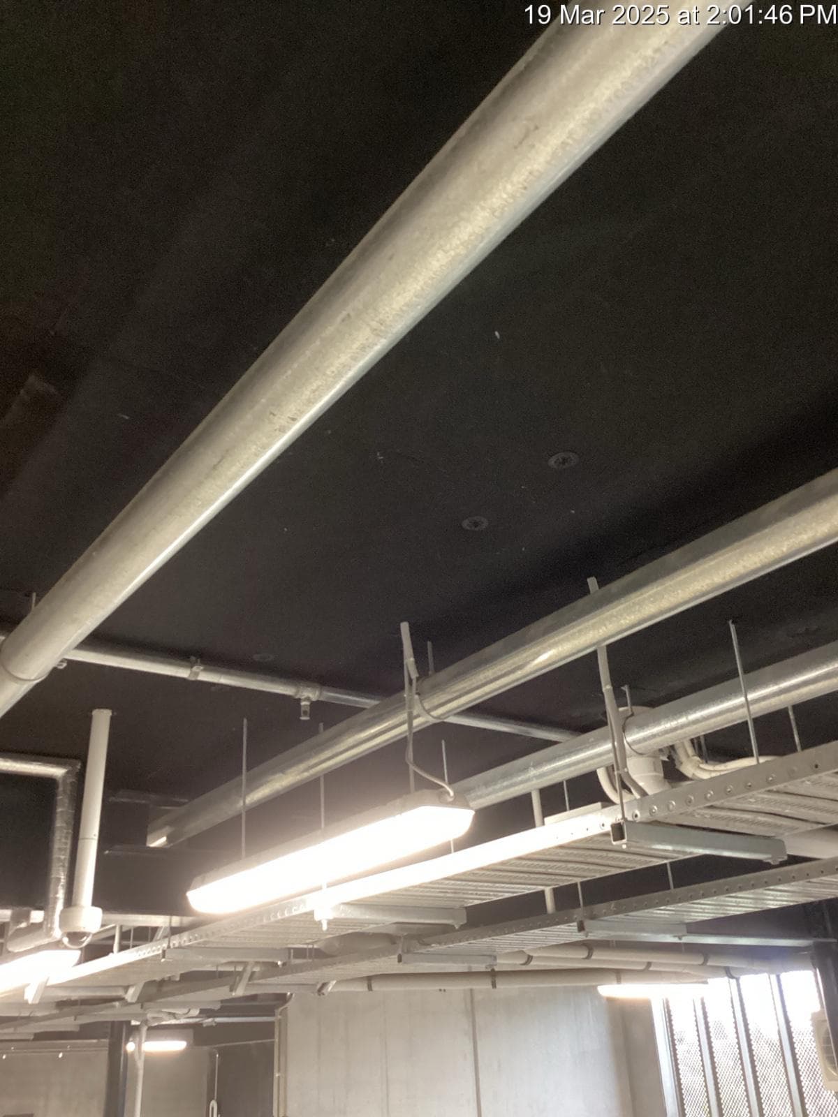 Concrete commercial car park interior with exposed services to the soffit